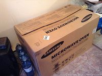 Closed cardboard box labeled Samsung Microwave Oven