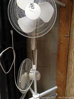 Two white Home Styles floor fans standing upright side by side with visible white plastic blades and front protective grills.