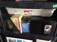 View of DVD and CD cases, poker set, black electronic box, and photo frame with floral image