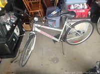 Silver SuperCycle 1500 bicycle leaning on rear wheel, visible brake cables and knobby tires.