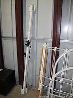 Full view of the wrought iron bed frame components including the headboard, footboard, and side rails showing assembled parts and paint condition.