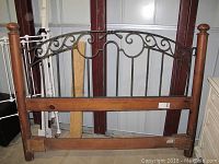 Full front view of the wood and iron headboard showing design and condition