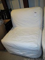 Fold out chair cot with white fabric cover, showing folds and stains, photographed from the front and side angles.