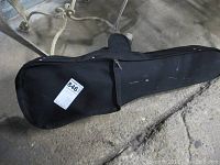 Closed black violin case showing outer soft shell and zippered front pocket.