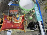 Red floral bamboo-themed tray with matching teapot, bamboo style planter, black cat teapot, green vase, Asian scroll in light blue box, wood box with hinged lid on glass table