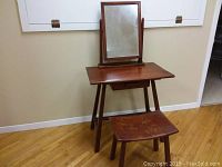 Table with mirror and bench against wall, showing overall lot