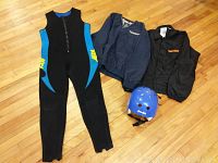 Photo showing all items laid out on floor: sleeveless wet suit, blue helmet, two jackets (one dark blue, one black)
