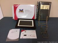 Digital photo frame, box, photo album and photo holders displayed on table