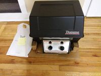 Front view of the closed BBQ grill showing the Ducane logo on the lid and the control panel with two burner knobs.