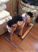 Child's brown stuffed rocking horse on metal rocking frame in room corner