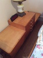 Mid Century Modern three tiered low dresser showing drawers and top with one glass panel present and two missing glass pieces, surface wear.