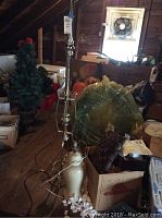 Photo of metal coat rack showing its height and multiple hooks, along with other items such as lamp base and miscellaneous attic contents