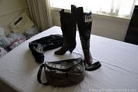 Gray suede and leather boots with metallic details, boot bag, and boot shaper arranged on table