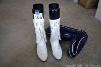 Front view of the white leather boots with fringe and boot shapers inside, showing size tag 5.5 and the navy boot bag to the side.