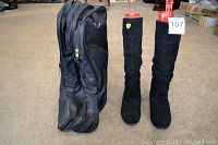 Photo showing the black boot bag standing next to both black suede scrunch boots with red boot shapers inside, front view.