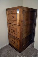 Full view of the oak filing cabinet showing three drawers and wood grain finish.