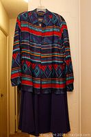 Multi-colored geometric pattern western blouse with dark matching skirt displayed on hanger
