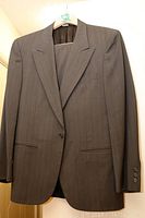 Brown pinstripe men's suit jacket on hanger