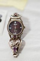 Close-up front view of sterling silver watch with amethyst accents and dark face showing Roman numerals and brand 'Native'