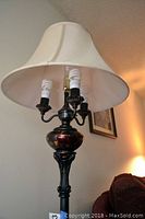 Full view of the floor lamp unlit, showing the brass and tortoise shell base with cream fabric shade.