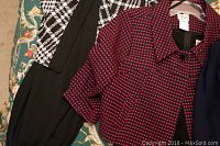 Close up of black and white houndstooth patterned top and dark pink patterned top of women's two-piece dress sets showing fabric and design details.