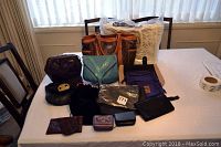 Wide view showing all purses and accessories arranged on a table.