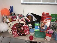 Wide shot showing multiple toiletry bags, handheld mirror, first aid supplies including Curad brand, ice bag, and small containers.