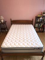 Full view of the full size bed frame with mattress installed, showing headboard and mattress top surface in room setting