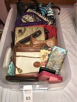 Clear plastic rolling storage bin filled with various assorted purses and wallets showing front view of lot contents.