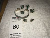 Photo showing silver jewelry set including a cuff bracelet, three rings, and a pair of earrings, all with turquoise stone inlays and decorative silver metalwork