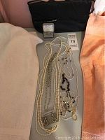 Full view of costume jewelry collection including pearl necklaces, bead necklaces, silver-tone earrings with cubic zirconia stones, and a ring in a box.