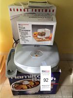 Photo shows George Foreman grill, Hamilton Beach food processor box, and Hamilton Beach crockpot box stacked together.