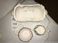 Top view of electric gravy dish with lid, creamer, and sugar bowl arranged on a table.