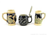Front view of 3 vintage beer steins, showing ornate relief scenes on ceramic steins and metal lid on smaller stein