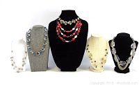 Six vintage necklaces arranged on display busts, various bead designs and colors shown.