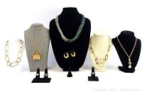 Full lot showing 5 necklaces on busts and display chain, 1 pair of earrings on stand, and 3 rings on ring holders.