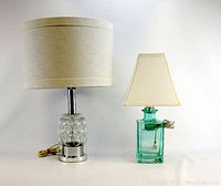 Photo of two vintage table lamps, left lamp with clear glass bubble base and chrome, right lamp green glass bottle base with cream shade.