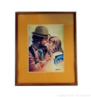 Framed clown art print showing clown and young girl nose-to-nose with orange matting and wooden frame.