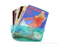 Photo of seven vintage Playboy magazines wrapped in blue bubble wrap showing front covers and edges.
