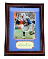 Framed memorabilia showing Earl Campbell running in Houston Oilers football uniform with plaque.