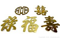 Set of five vintage brass Chinese character trivets laid out on a flat surface, showing various stylized characters representing good fortune, longevity, prosperity, and happiness.