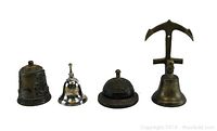 Four vintage bells displayed in a row on a white background: from left, ornate brass handbell, small silver-tone handbell, round embossed floral desk bell, and tall brass bell with anchor-shaped handle.