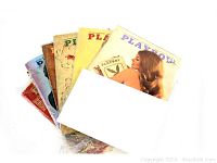 Seven vintage Playboy magazines from the 1970s, fanned out to show front covers with various models and classic logos. Condition shows typical vintage wear.