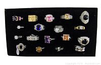 Photo showing 18 new rings featuring various semi-precious stones on a black display tray.