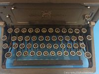 Front view of the Imperial typewriter keyboard showing round keys with black and gold lettering.