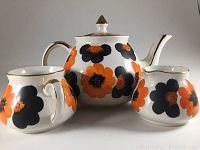 Full view of teapot, milk jug, and sugar bowl showing poppy flower decoration