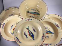 Top view of five of the six smaller bowls arranged around the large bowl, showing colorful fish designs inside.