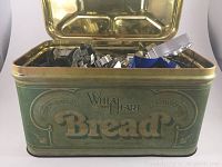 Front view of the Wheat Heart bread tin, open to show cookie cutters inside.
