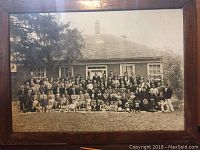 Front view of the large black and white group photo in a wooden frame.
