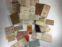 Overview of assortment showing documents, booklets, tickets and patches laid out